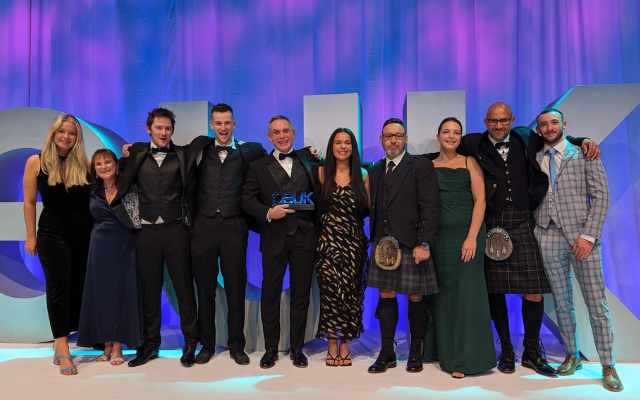 Imrandd colleagues on stage at an awards gala, one holding an OEUK award plaque