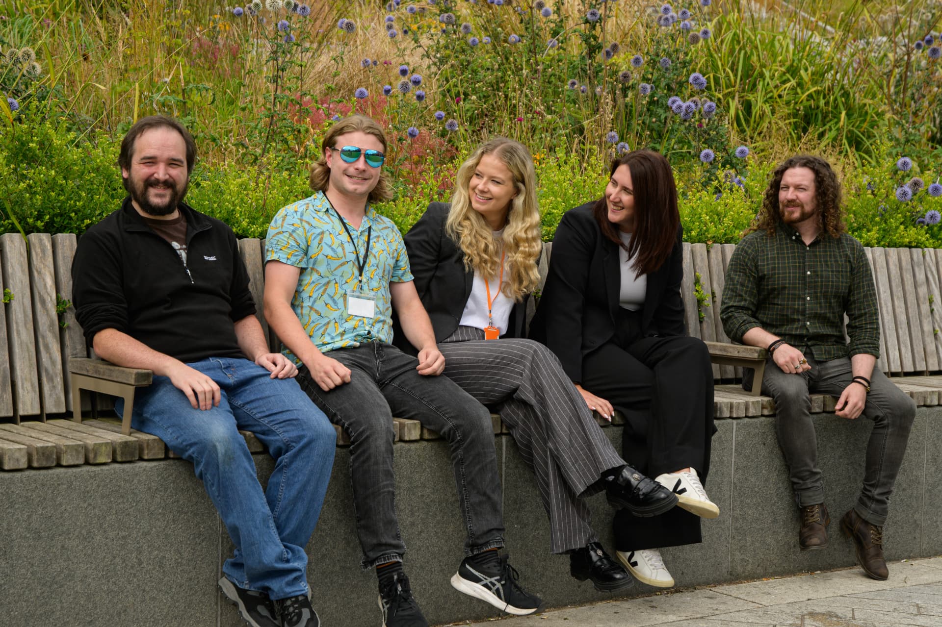 Five Imrandd colleagues sitting side by side on a bench outdoors