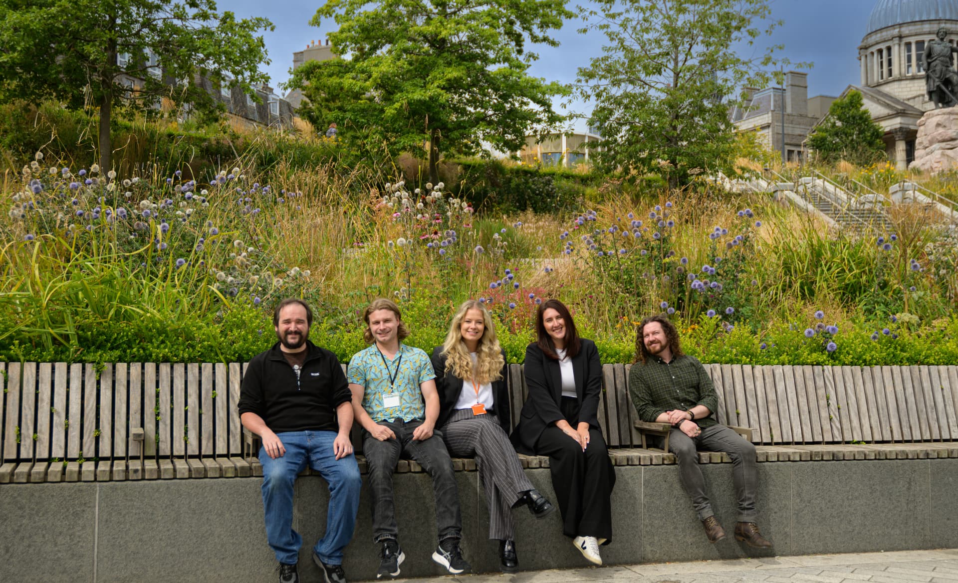 Imrandd team members sitting together on a bench outside