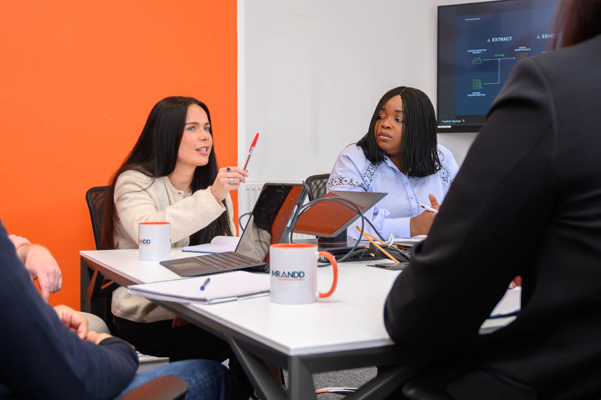 Imrandd colleagues collaborating around a table in a bright office